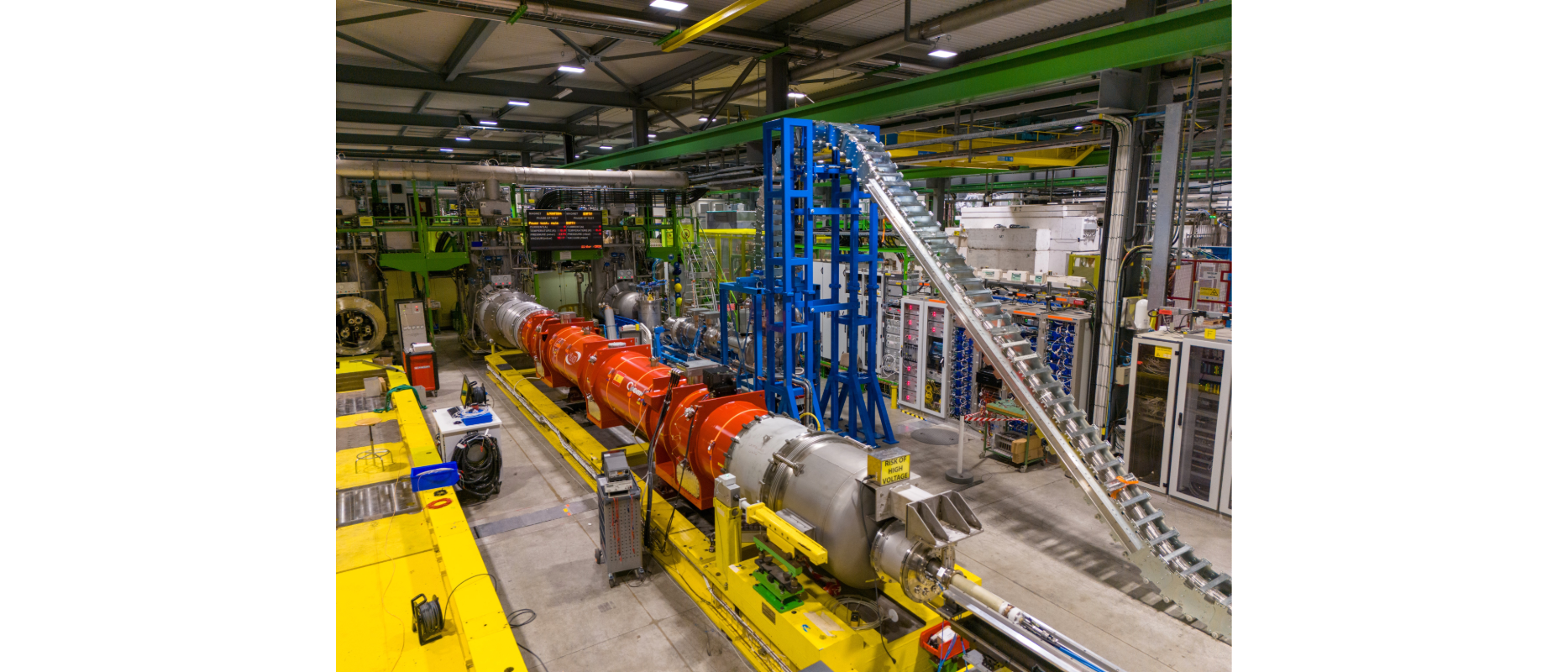cylindrical red magnet in front of train track-like silver equipment