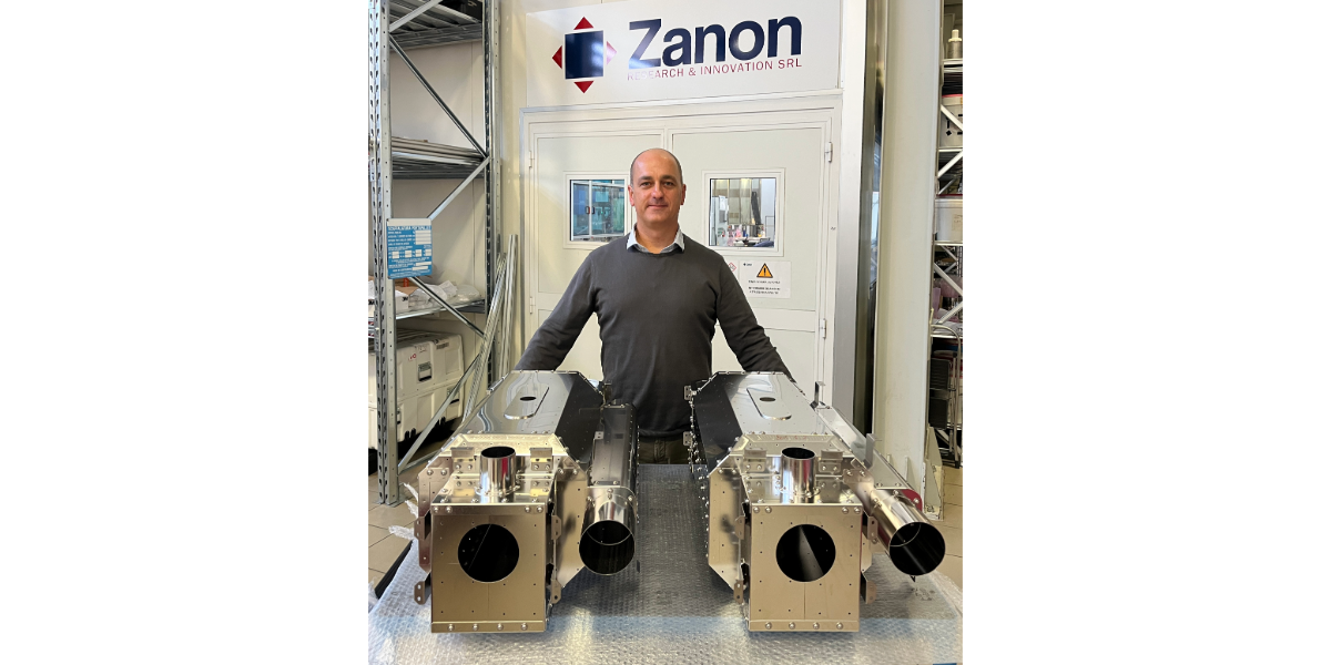 man standing with magnetic shields and helium tank materials in front of Zanon logo