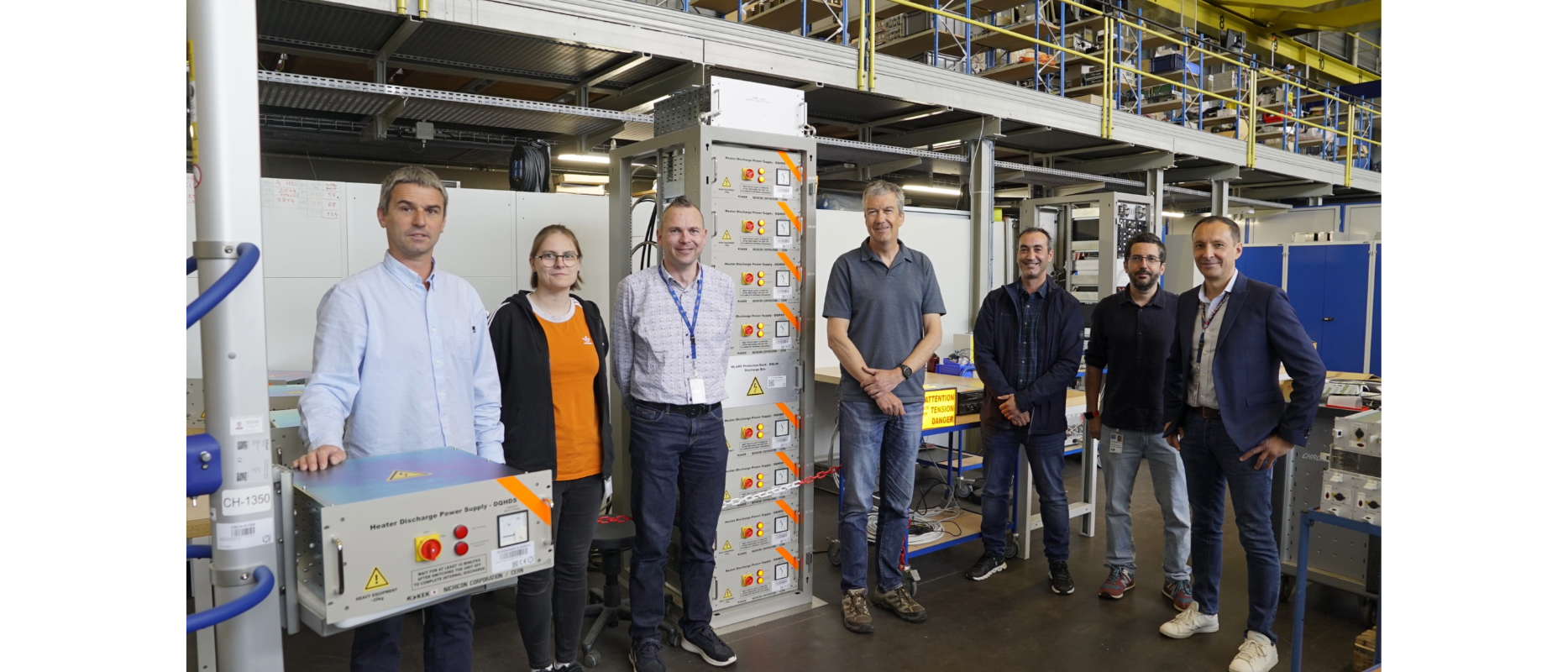 people smiling in front of box-like equipment